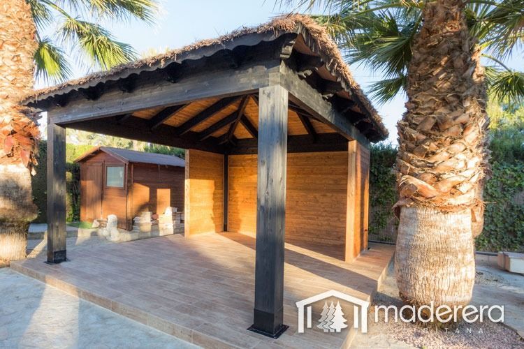 Una estructura de madera con techo de paja está rodeada de palmeras.