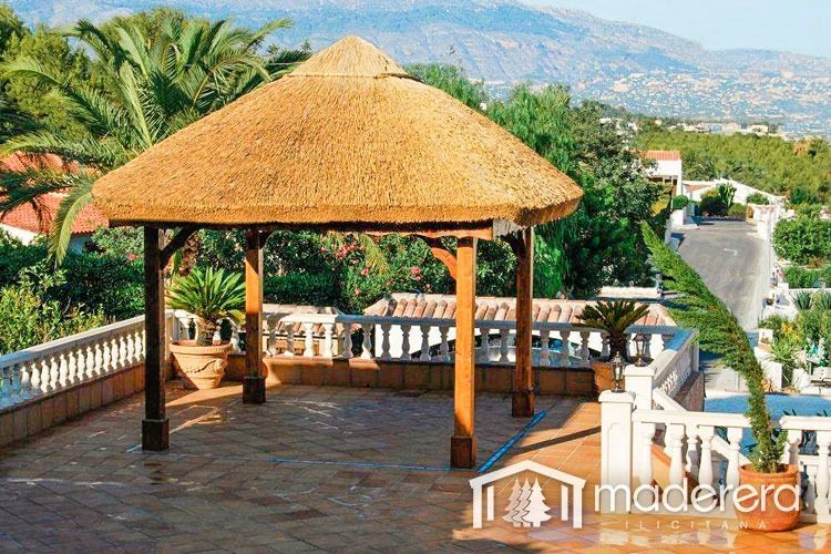 Un cenador de madera con techo de paja en la azotea.