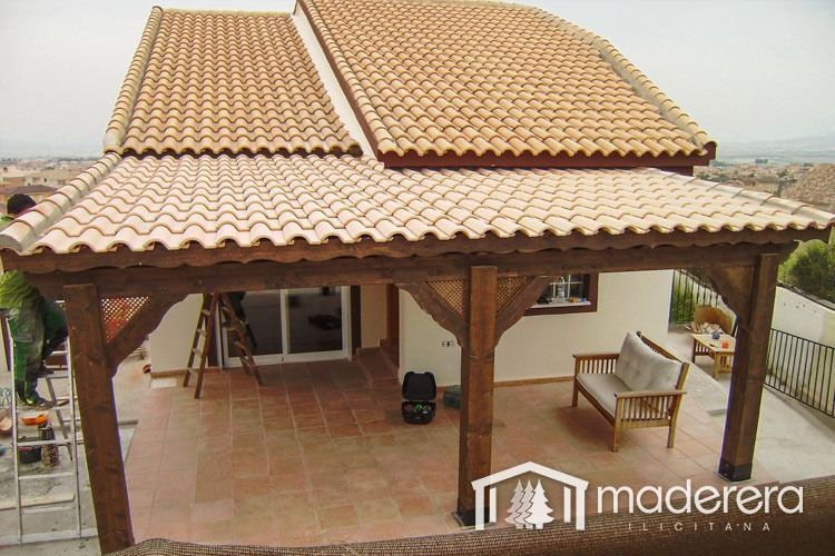 Una casa con un porche de madera y un techo de tejas