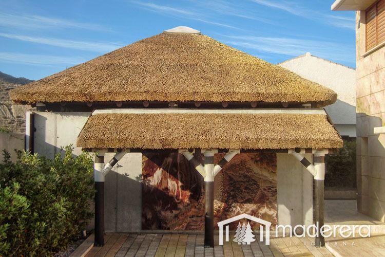 Un edificio con techo de paja y un cartel que dice maderarera