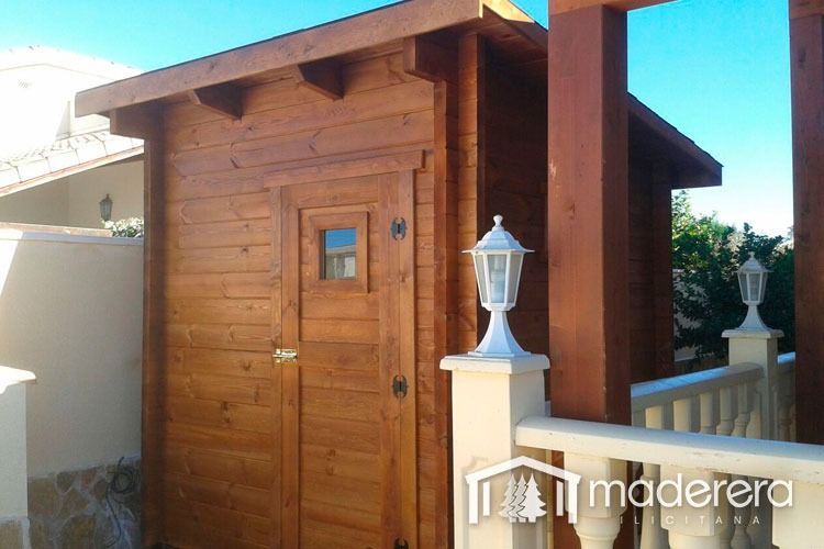 Un pequeño cobertizo de madera con una puerta y una ventana.