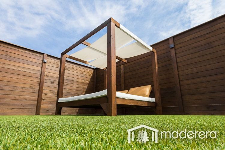 Una cama con dosel se encuentra sobre un exuberante césped verde.