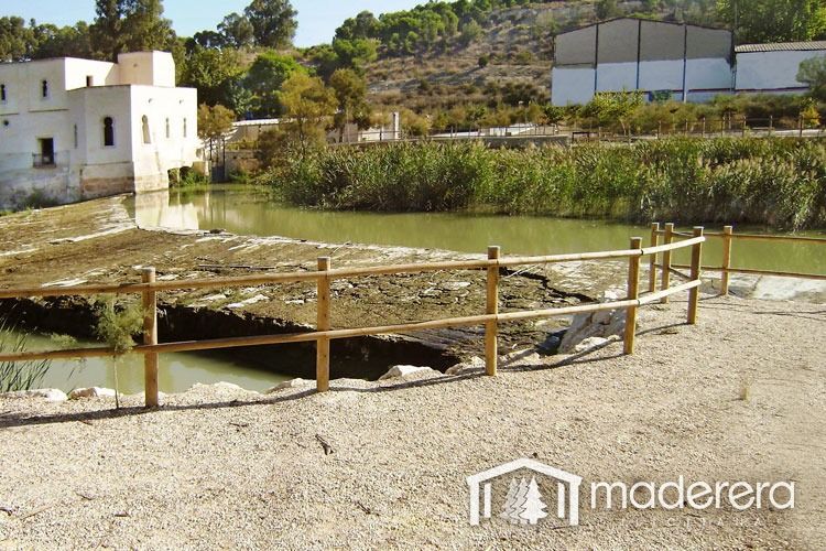 Una valla de madera rodea un cuerpo de agua con la palabra madera en la parte inferior