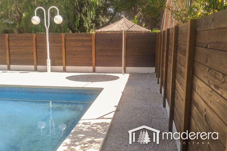 Una valla de madera rodea una gran piscina.