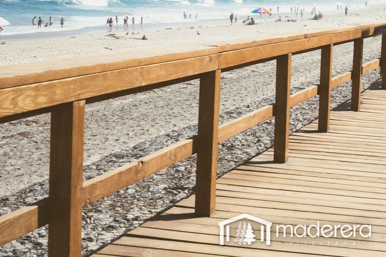 Una pasarela de madera que conduce a una playa con gente caminando por ella.