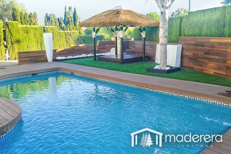 Una gran piscina con un cenador de paja al fondo.