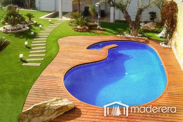 Una gran piscina está rodeada por una terraza de madera.