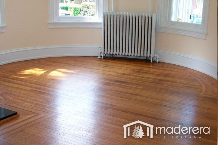 Una habitación vacía con suelo de madera y radiador.
