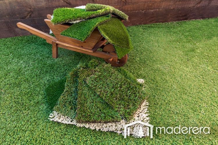 Una carretilla de madera llena de trozos de césped artificial.