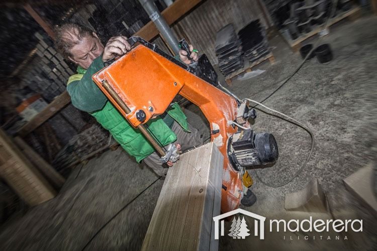Un hombre está cortando un trozo de madera con una máquina que dice maderarera.