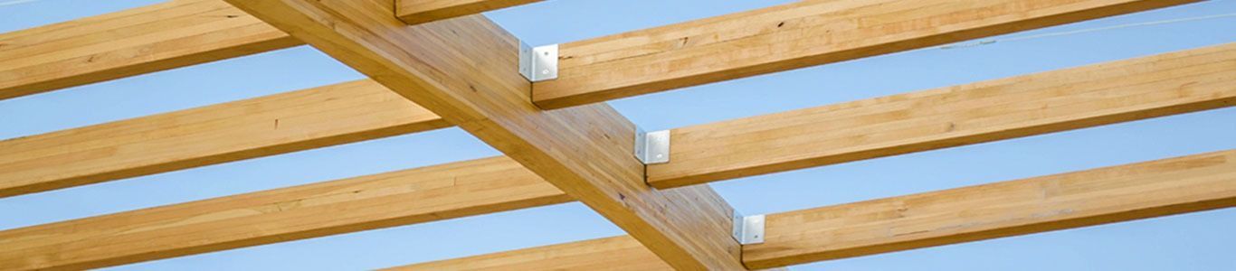 Un primer plano de una estructura de madera con un cielo azul de fondo.