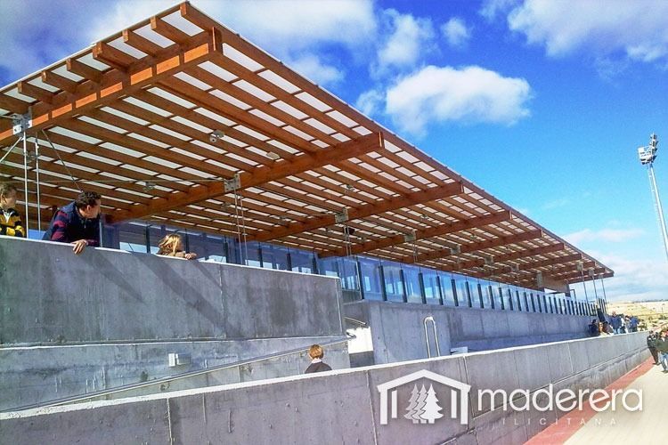 Un grupo de personas está sentada bajo un techo de madera.