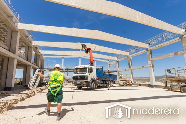 Un trabajador de la construcción está parado frente a un camión en un sitio de construcción.