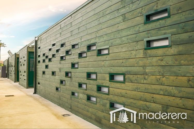 Una pared de madera verde con agujeros y la palabra madera en la parte inferior.