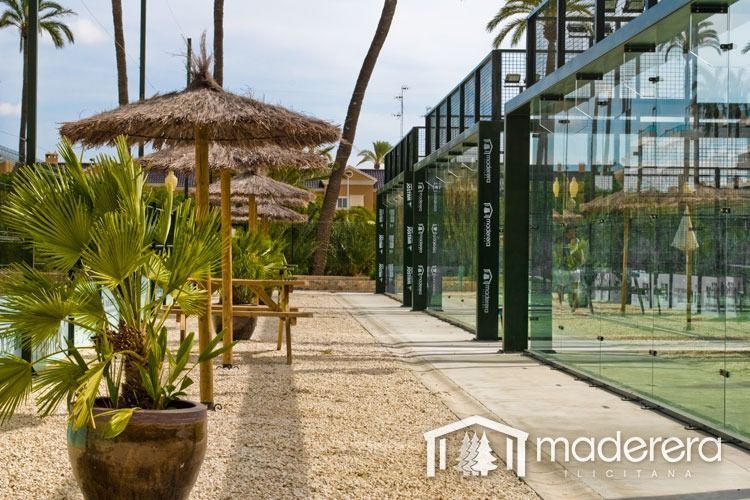 Una planta en maceta está frente a un edificio que dice madera.