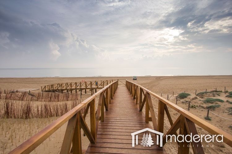 Una pasarela de madera que conduce al océano con la palabra madera en la parte inferior.
