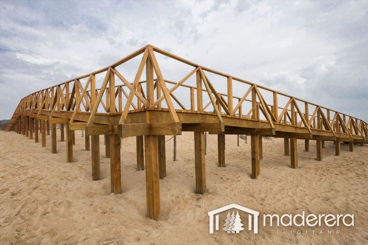 Una pasarela de madera en una playa con la palabra madera en la esquina