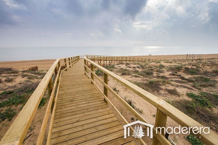 Una pasarela de madera que conduce a una playa en el desierto.