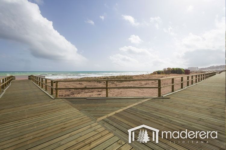 Una pasarela de madera que conduce a una playa con la palabra madera en la parte inferior.