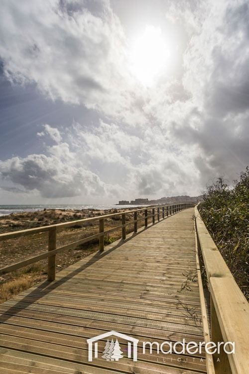 Una pasarela de madera que conduce al océano en un día nublado.