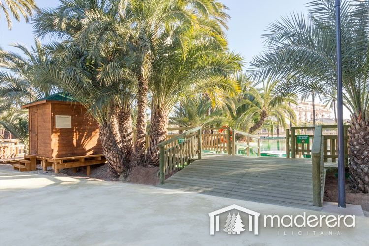 Una casa de madera está rodeada de palmeras en un parque.