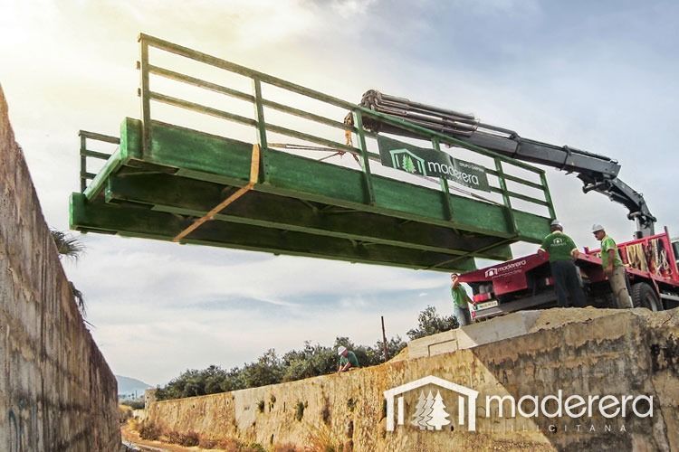 Una grúa está levantando un puente sobre un río.