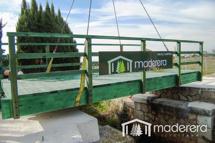 Un puente verde con un cartel que dice madera