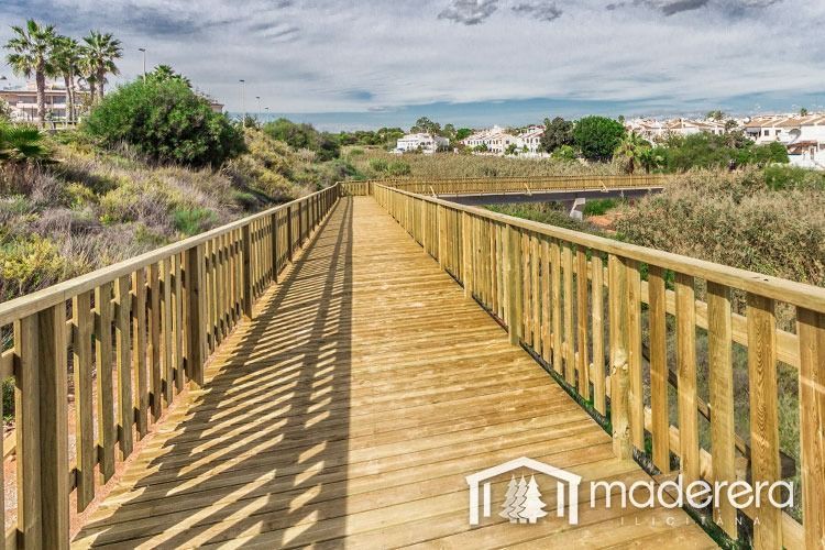 Una pasarela de madera que conduce a un puente sobre un río.