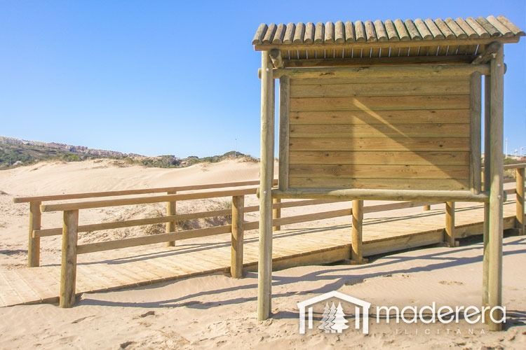 Una estructura de madera en una playa con un cartel que dice maderarera