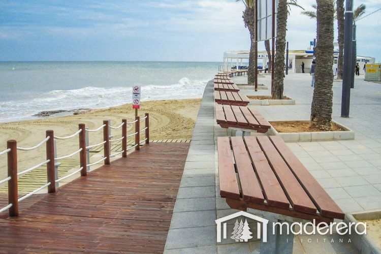 Una fila de bancos de madera en un paseo marítimo junto al océano.