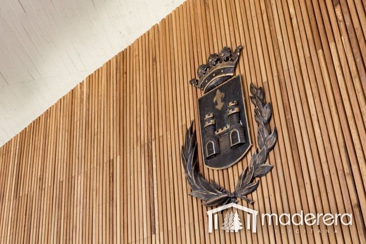 Una pared de madera con un escudo de armas.