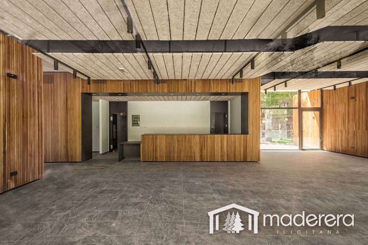 Una gran habitación vacía con paredes de madera y un mostrador de madera.