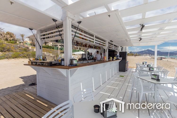 Un chiringuito con mesas y sillas bajo un dosel.