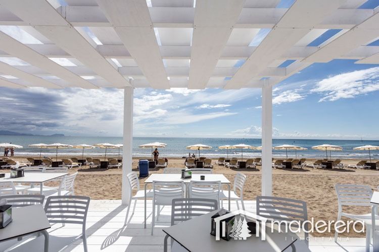 Mesas y sillas en una playa con la palabra madera en la parte inferior.