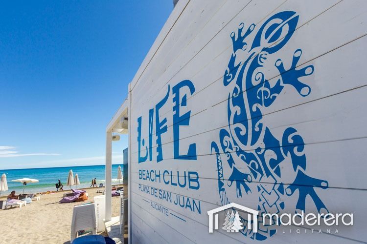 Un cartel de club de playa con un lagarto.