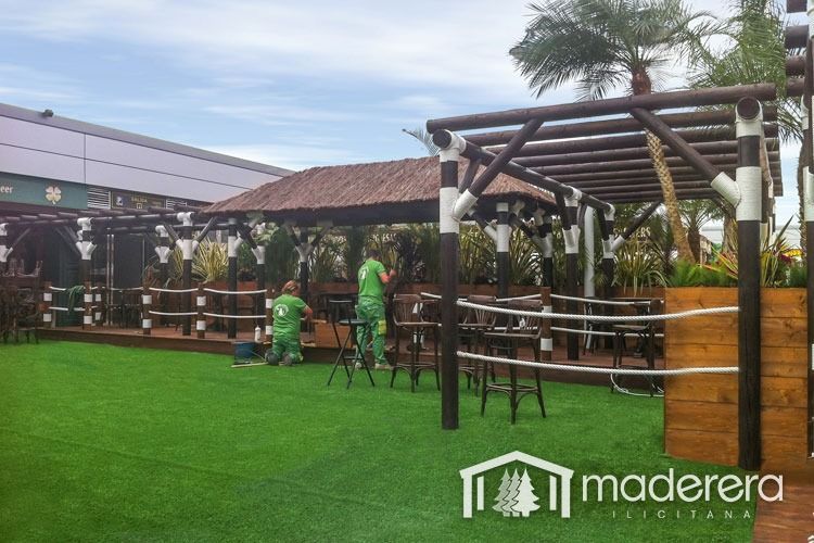 Un grupo de personas está trabajando en una pérgola en un jardín.