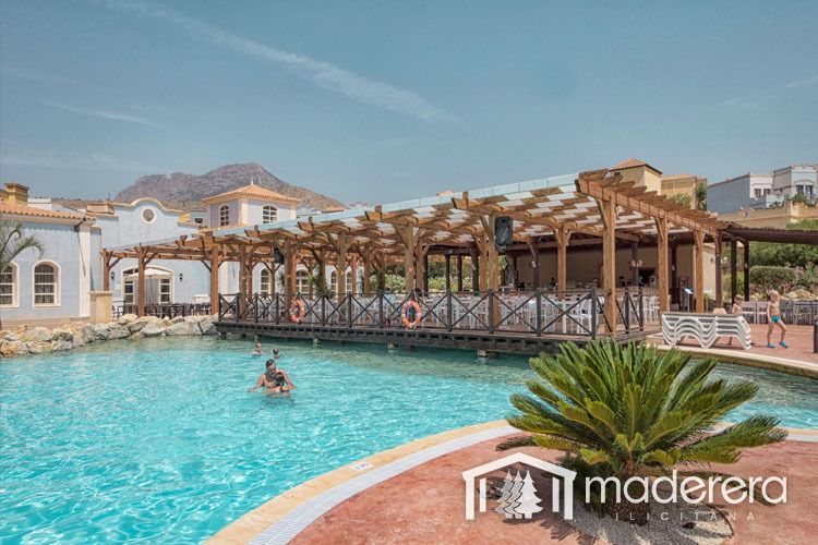 Un hombre está nadando en una gran piscina en un complejo turístico.