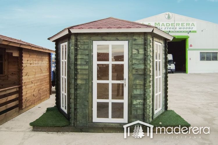 Un cobertizo de madera con techo rojo está frente a un edificio que dice madera.