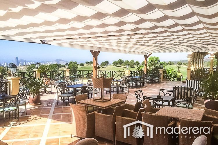 Un patio con mesas y sillas y un cartel que dice maderarera