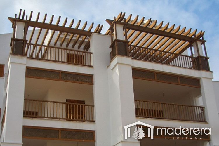 Un edificio blanco con balcones y un cartel que dice madera