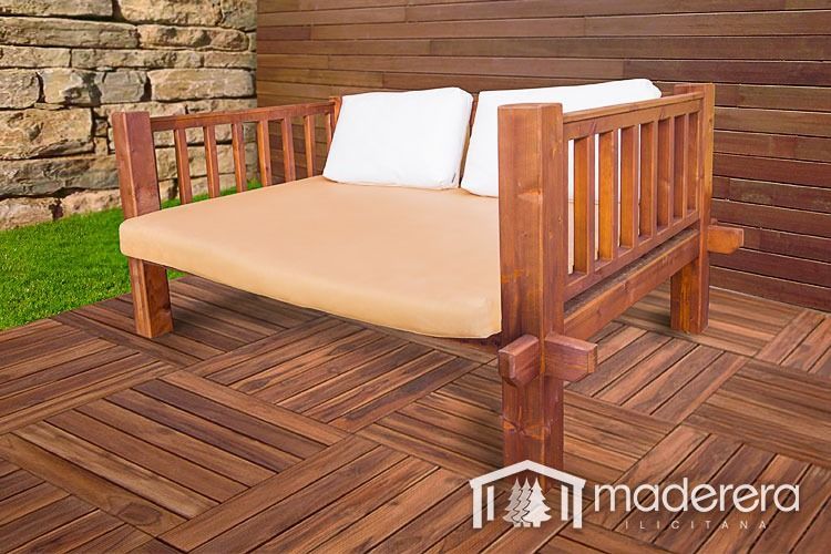 Un sofá de madera con cojines blancos está sentado sobre una terraza de madera.