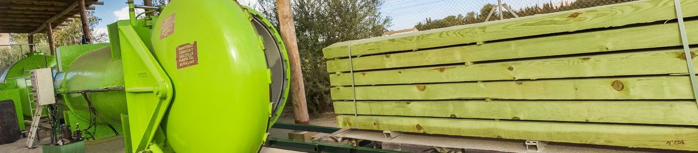Una máquina verde está sentada junto a una valla de madera.