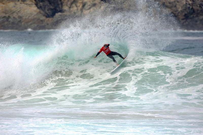 Un hombre está montando una ola en una tabla de surf en el océano.