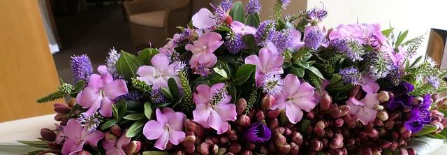 Un ramo de flores moradas está sobre una mesa.