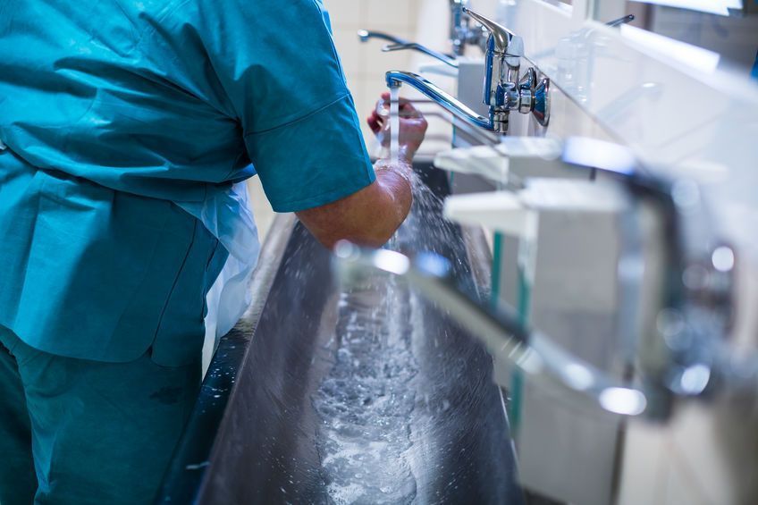 Un cirujano se lava las manos en el lavabo de un hospital.