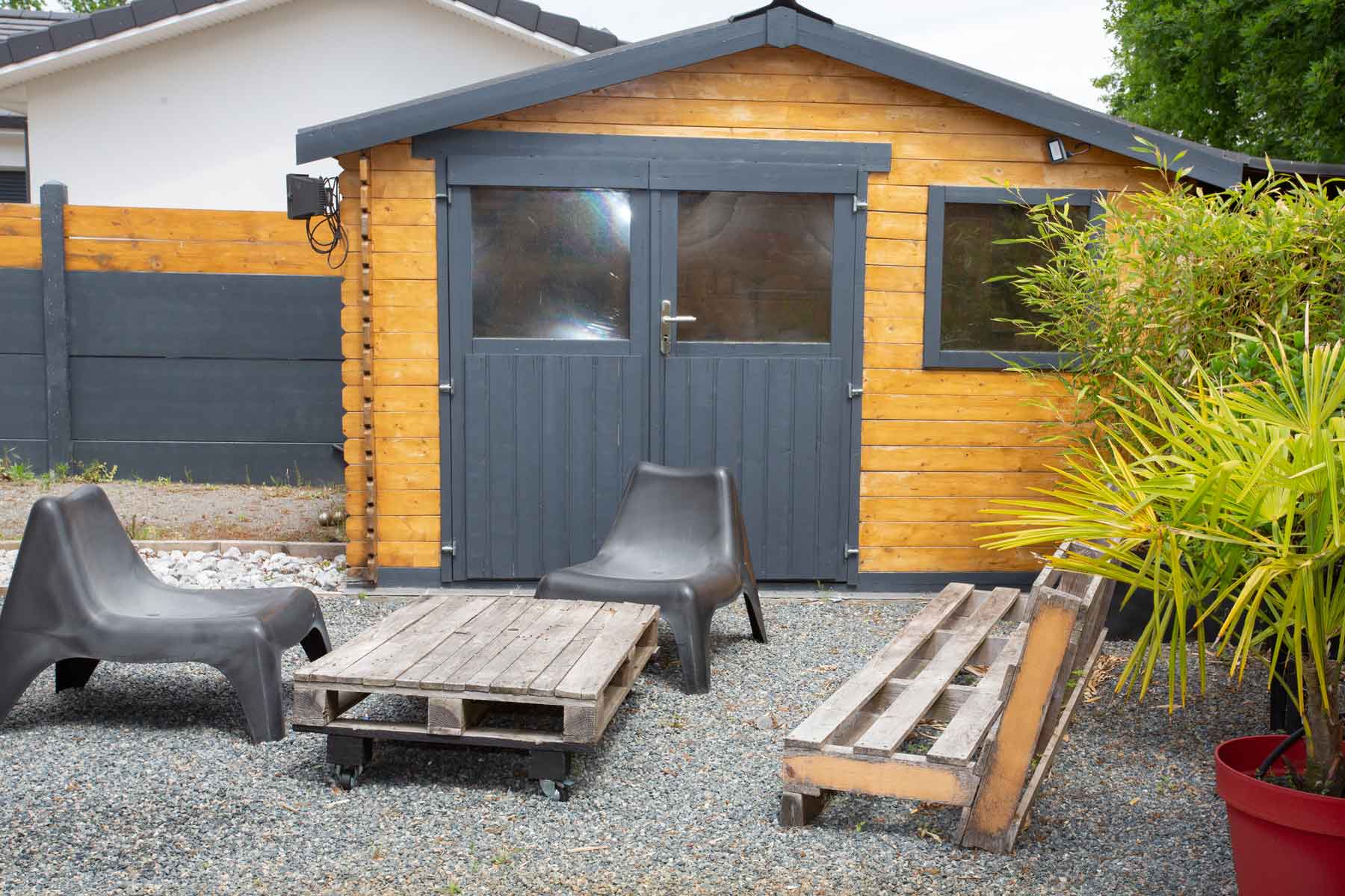 Abri de jardin avec chaises et banc en palettes de bois