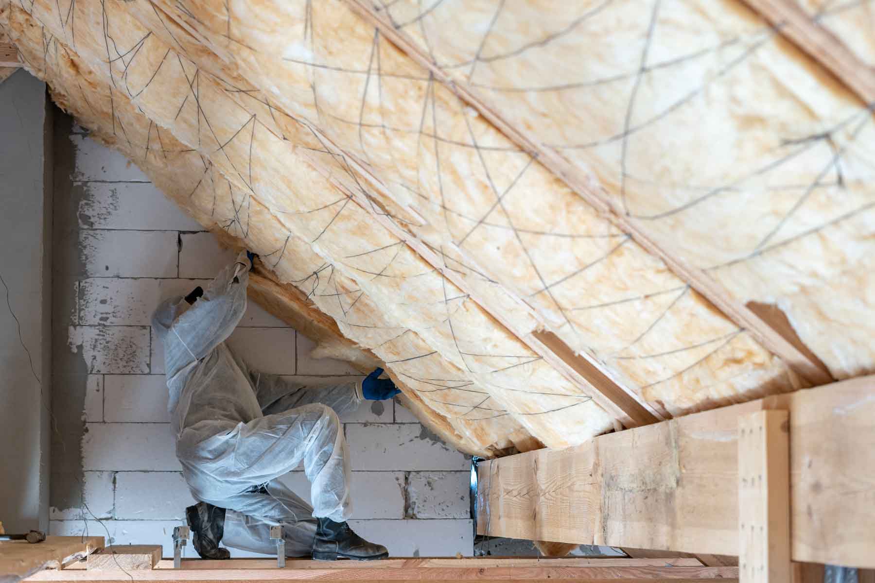 Technicien à genoux réalisant une isolation des combles