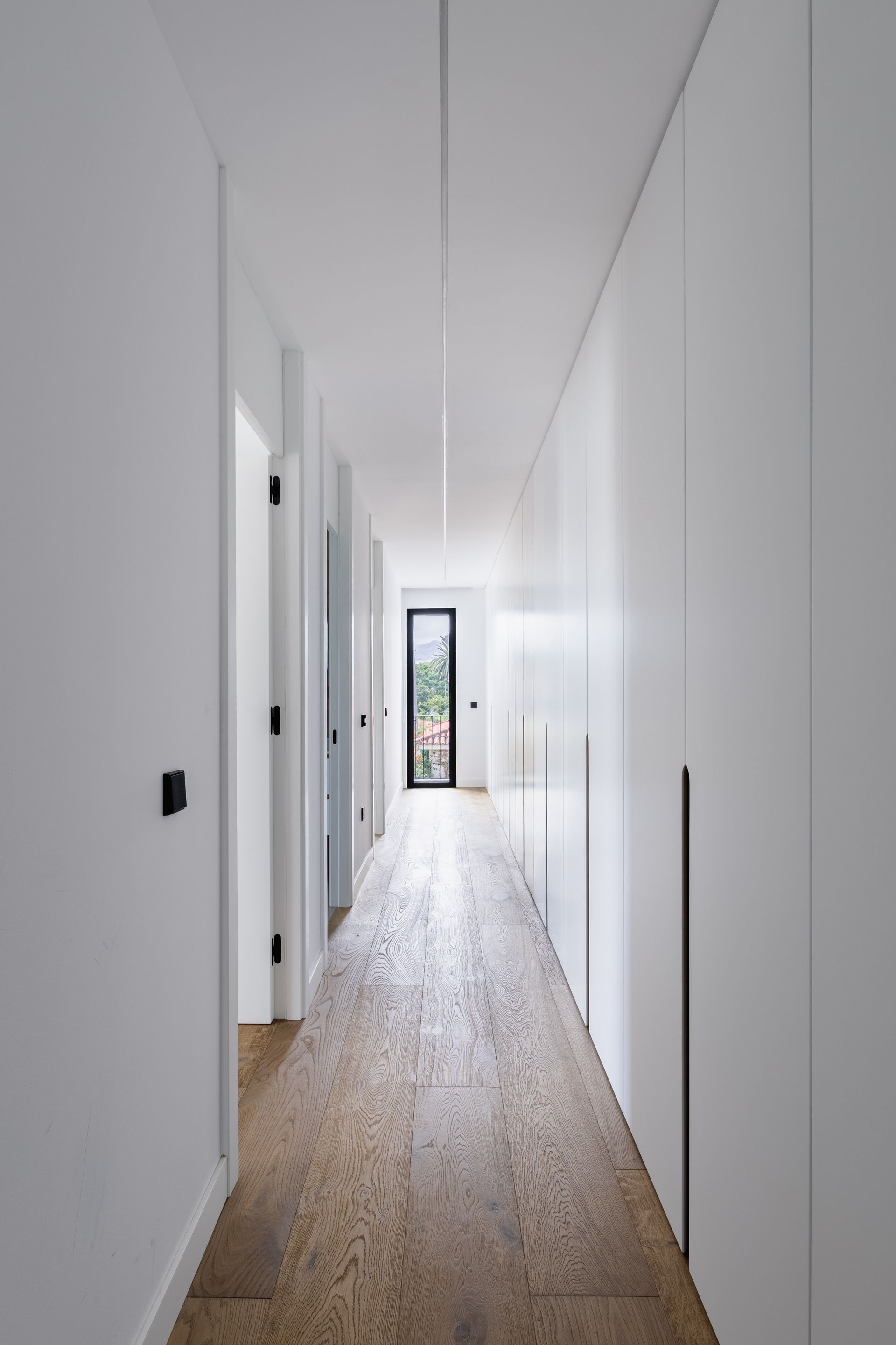 Armarios a medida Una sala de estar con una silla, una mesa y una lámpara.