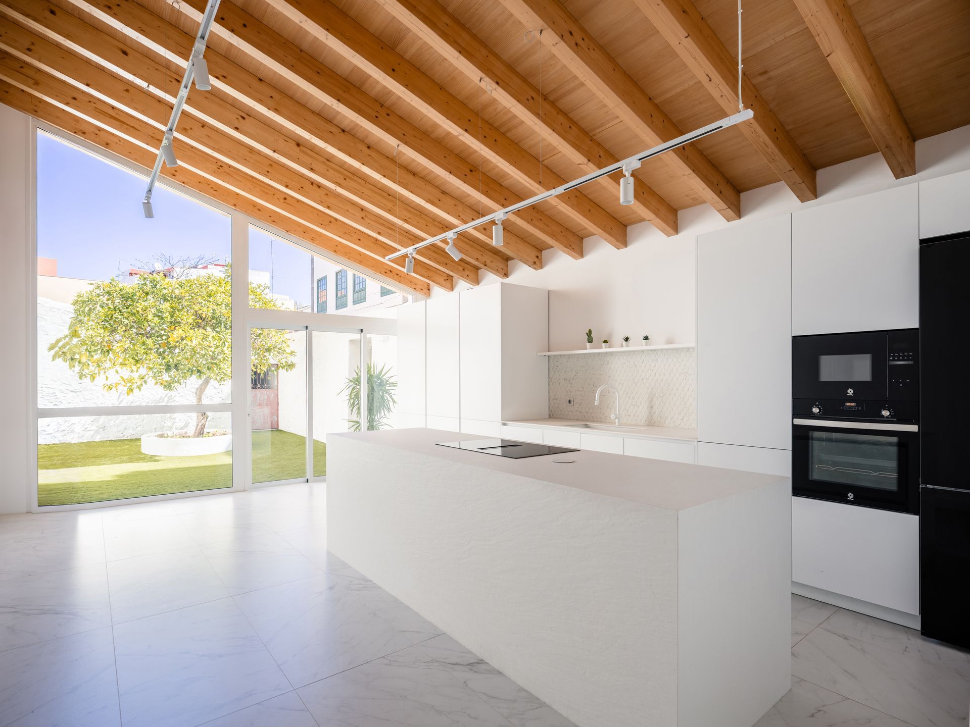 Una cocina con una gran isla y taburetes en ella.