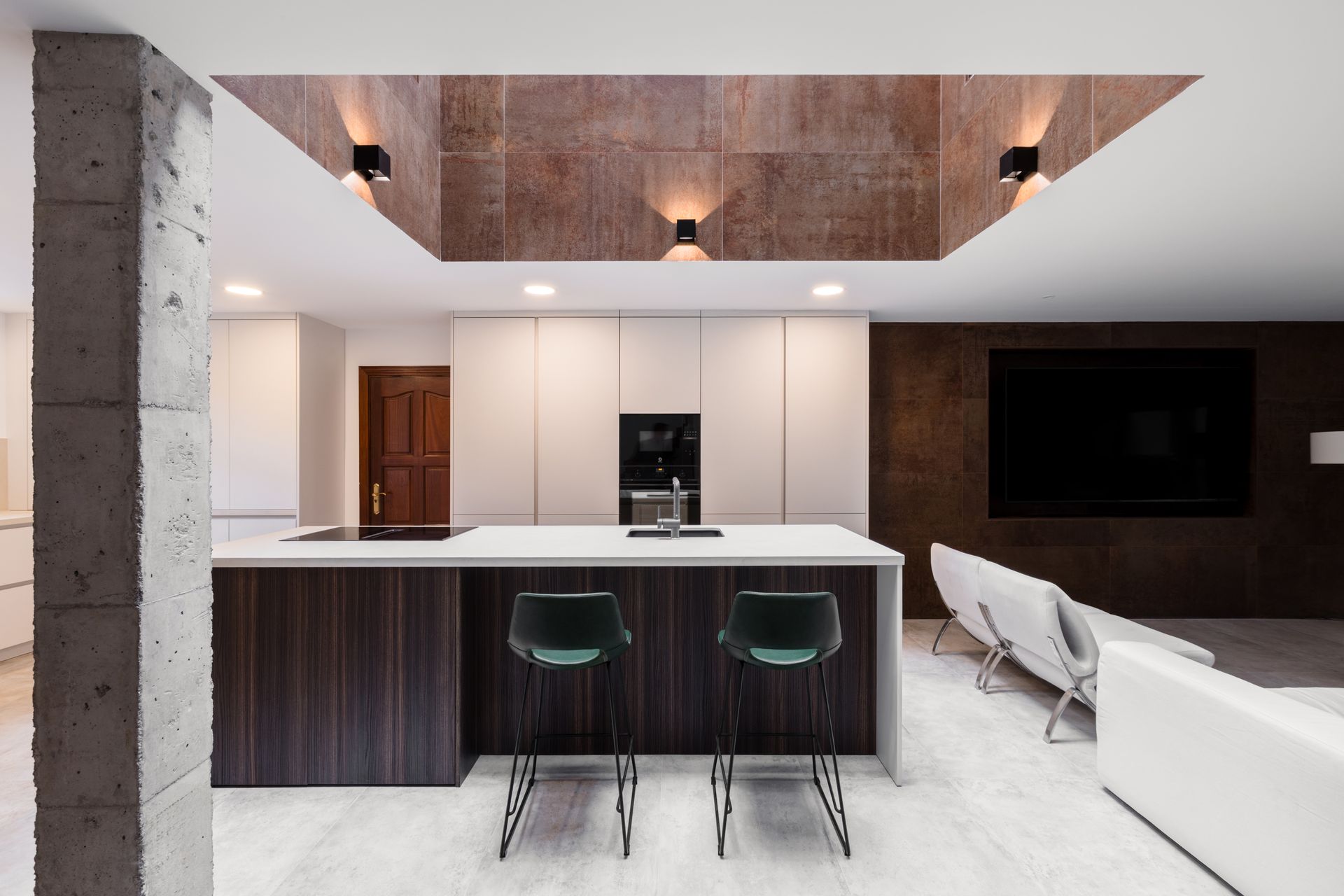 Una sala de estar con pisos de madera y muebles blancos.